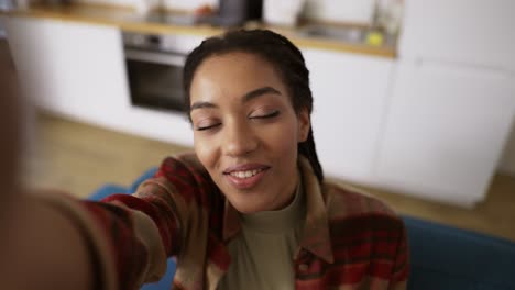 Foto-De-Punto-De-Vista-De-Una-Chica-Afroamericana-Tomando-Selfie-Sonriendo-Posando-Mirando-La-Cámara-Sola-En-Casa