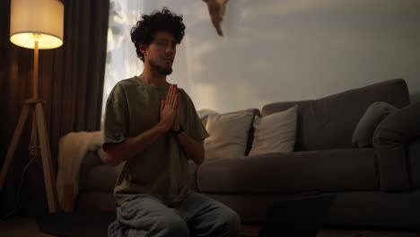 hombre meditando en casa con una computadora portátil