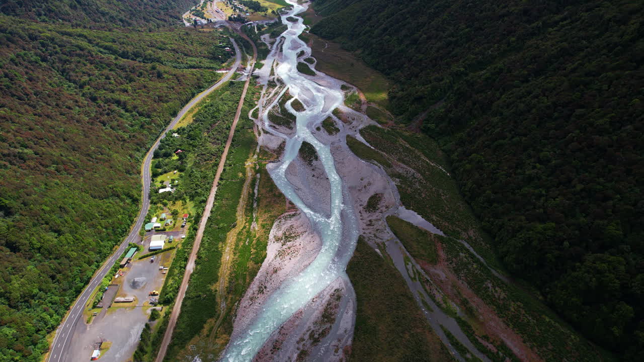Drone following the Otira River through the Gorge, in New Zealand, sunny day