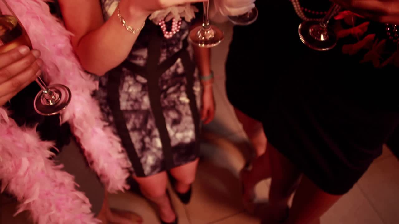 Nærbilde av hender som løfter champagneglass, kvinner som skåler i baren, hjerter som multipliseres for utelivsfesten