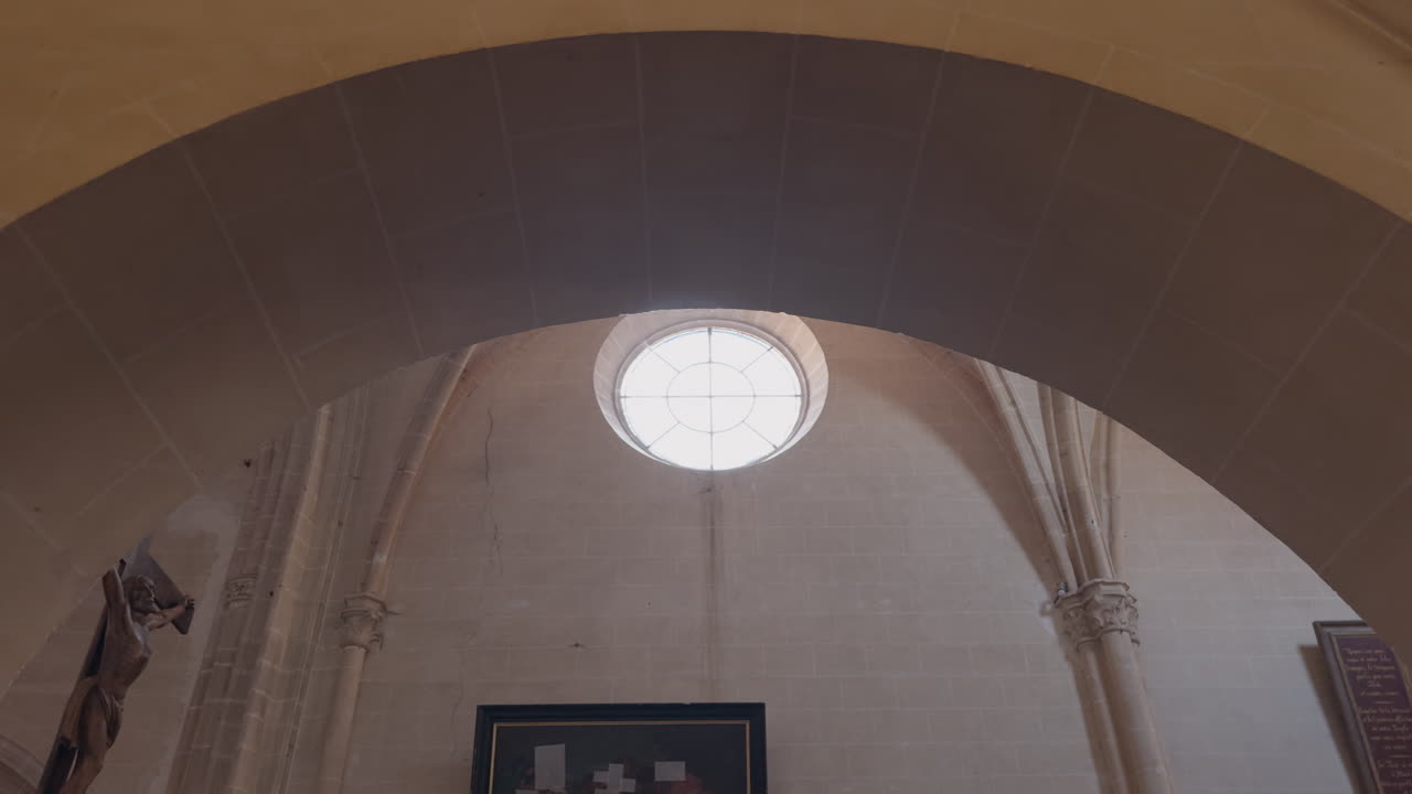 Inquadratura dal basso di una finestra circolare illuminata dal sole nella Chiesa di Saint-Fargeau in Francia.