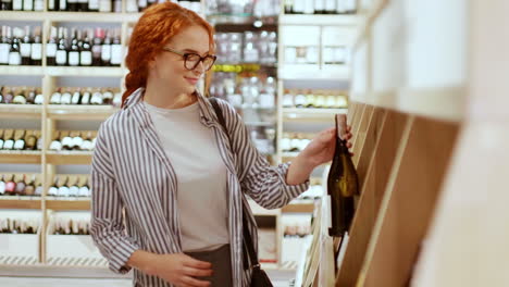 Kaukasische-Junge-Frau-Wählt-Eine-Flasche-Wein-In-Einem-Supermarkt