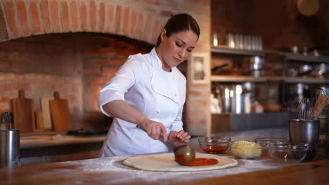 female chef preparing pizza in a rustic kitchen