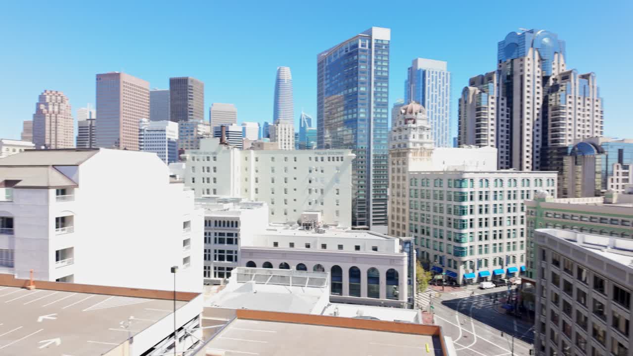 Panning rooftop perspective of San Francisco downtown highlights modern high-rises beside older urban structures