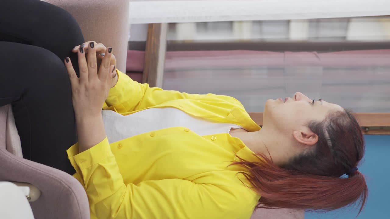 집에서 신경 ⁇ 약을  ⁇ 고 있는 여성의 수직 비디오가 소리를 지르고 있습니다.