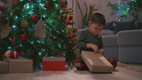 Adorable-three-year-old-boy-opening-his-Christmas-gift-and-finding-a-teddy-bear-inside.-High-quality-4k-footage