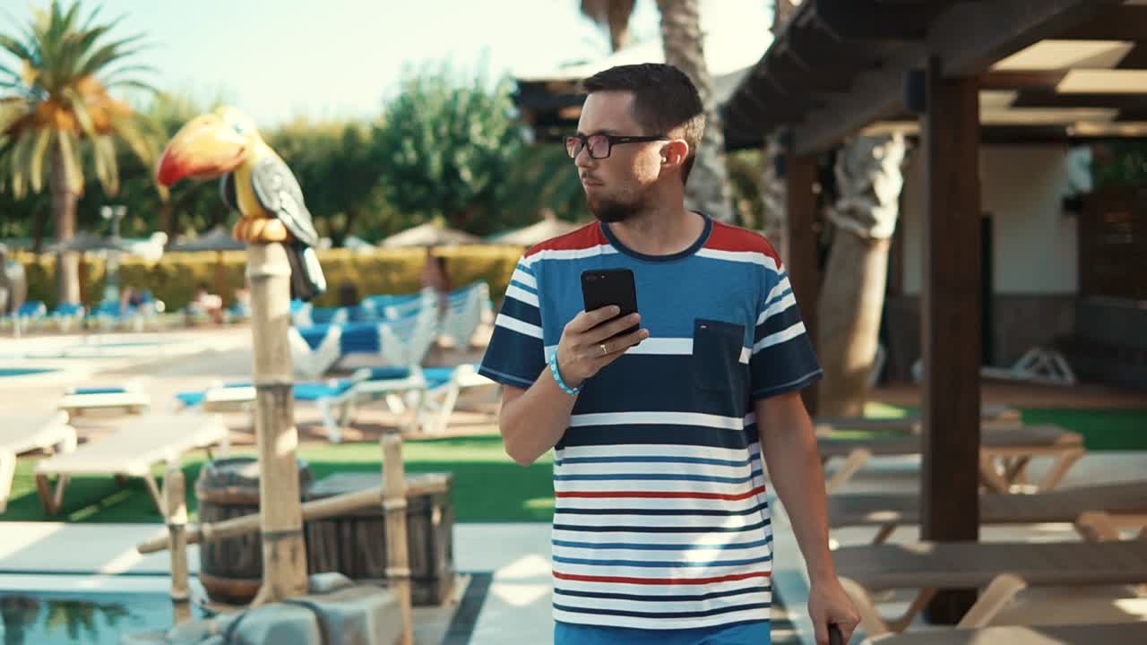hombre usando el teléfono por la piscina