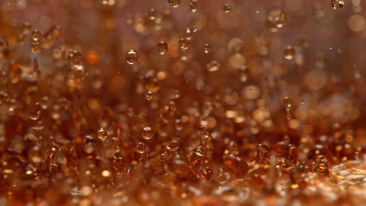 la soda gaseosa salpica y crea ondas estacionarias, líquido marrón abstracto en macro y cámara lenta