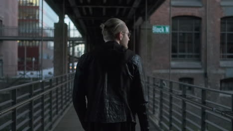 man walking on a bridge in the city