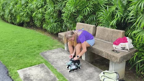 woman putting on roller skates in a park