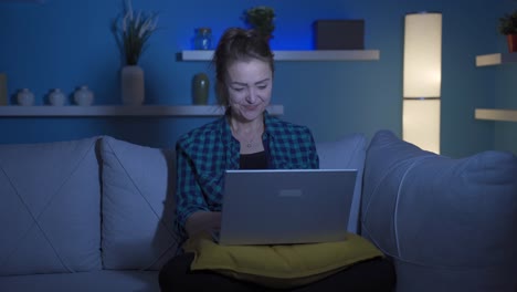 Happy-woman-using-laptop-at-night.