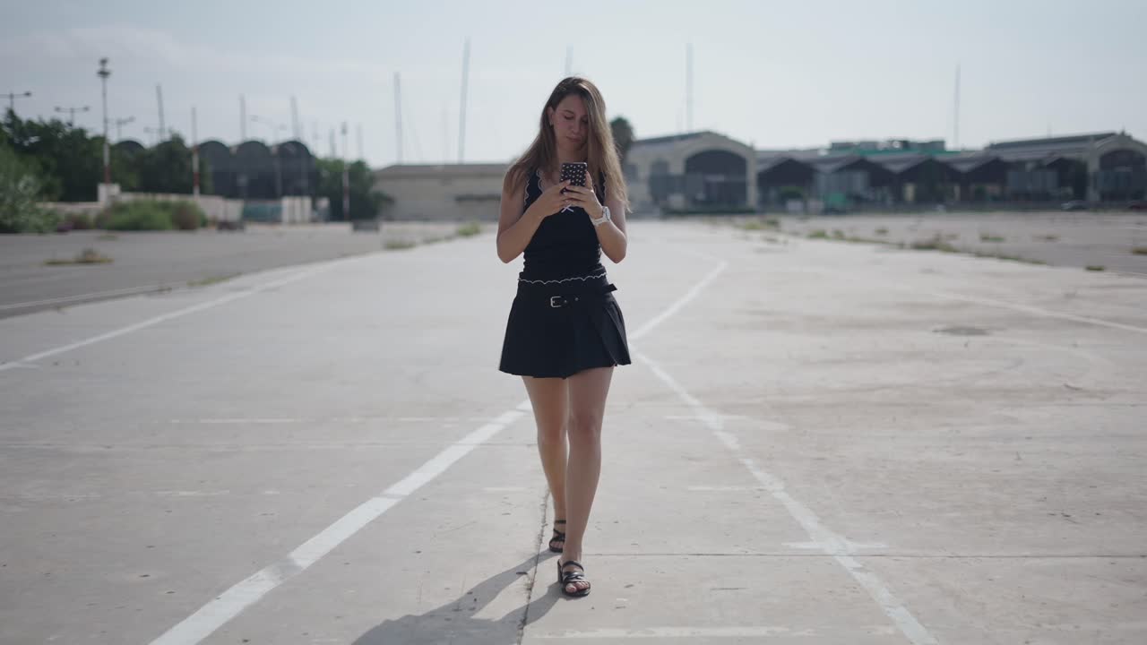 Donna che cammina e usa il telefono in un contesto urbano