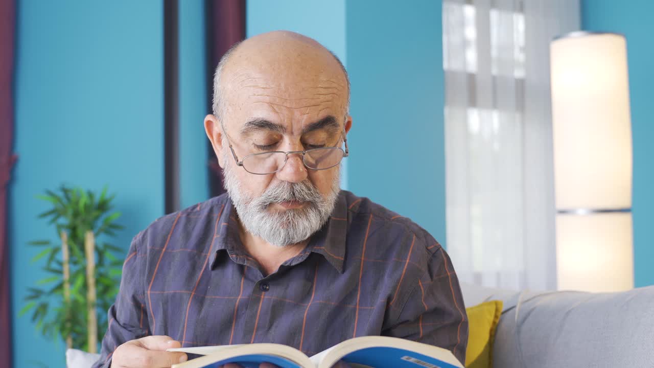 un anciano culto leyendo un libro en casa.