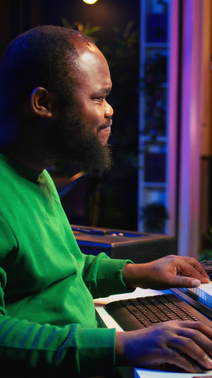 African American Man Playing MIDI Keyboard in Music Studio