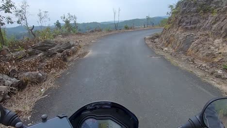 motociclista montando bicicleta en los bosques senderos en el día desde un ángulo plano