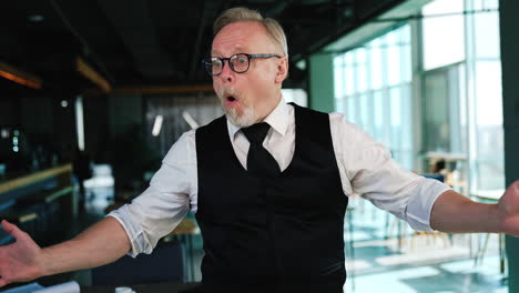 astonished adult man wearing white shirt and black vest spread his hands to the sides. man wearing eyeglasses looks around with surprise. close up.