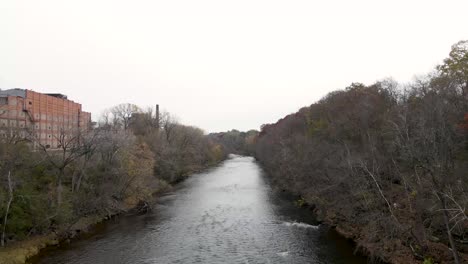 Den-Chippewa-River-In-Eau-Clare,-Wisconsin,-Mit-Einem-Alten-Steingebäude-Hinuntergleiten