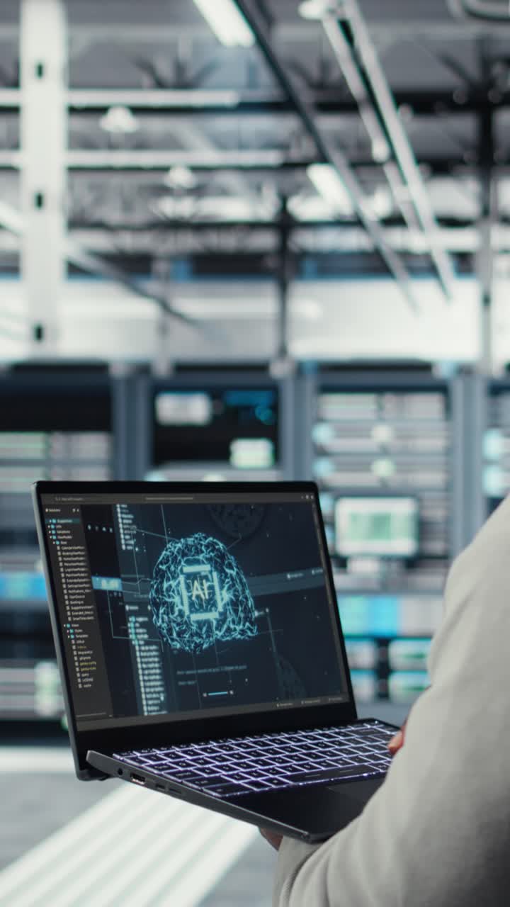 Vertical video Software developer in data center uses AI technology on laptop
