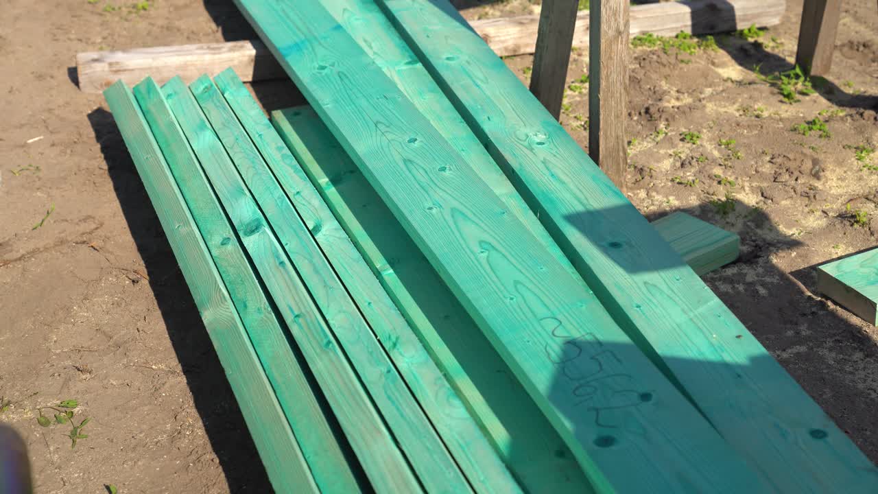 Stacked impregnated lumber planks on construction site outdoors