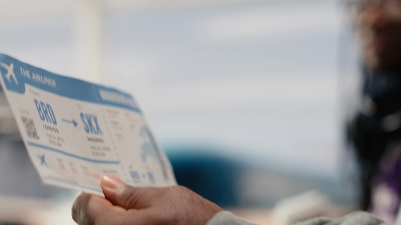 Close up of airplane ticket used by people walking in airport terminal