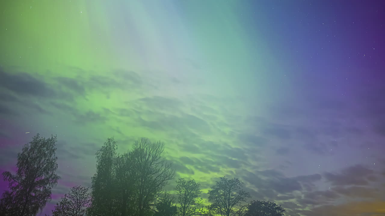 el lapso de tiempo de las coloridas luces del norte moviéndose sobre el horizonte en la noche llena de estrellas