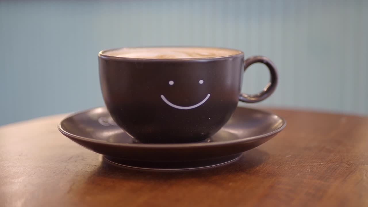 Primo piano di una tazza di caffè con una faccina sorridente sopra