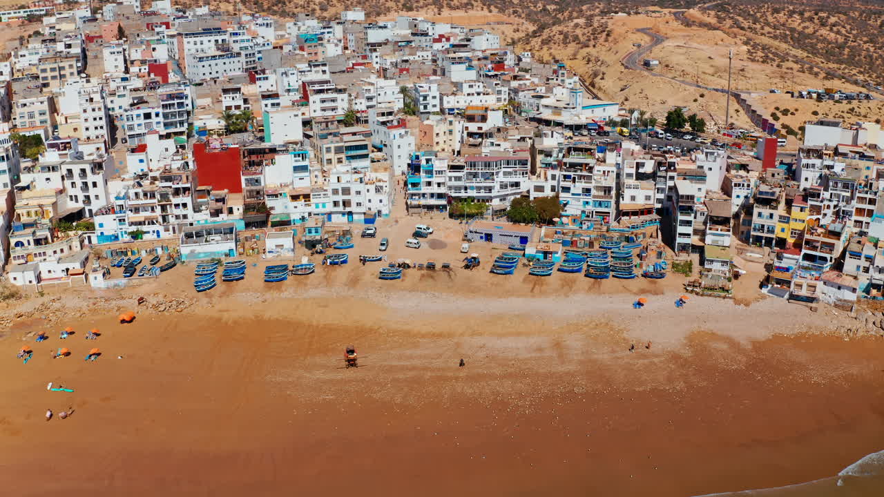 Aerial drone shot over the local beach town of Taghazout in Morocco.