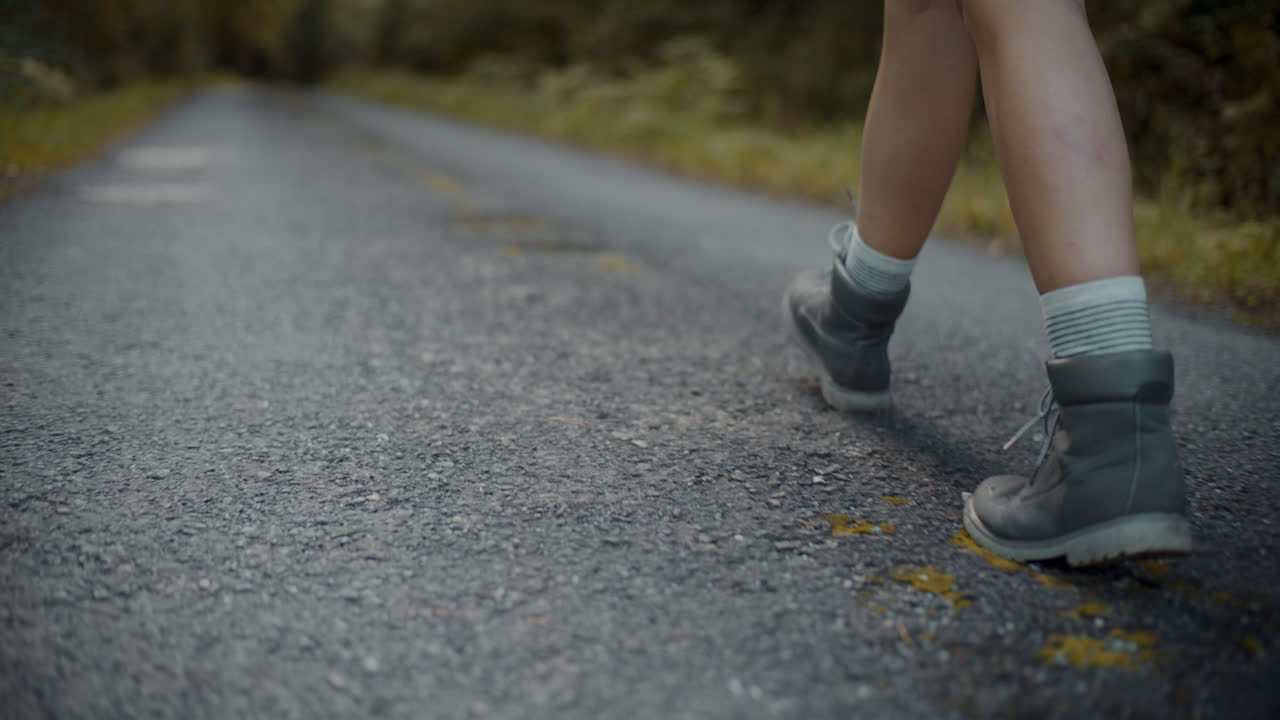 mujer con zapatos caminando por la carretera