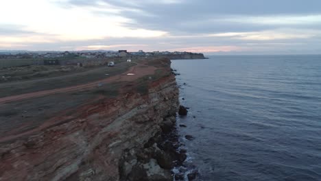 coastal cliff at sunset with town in the distance