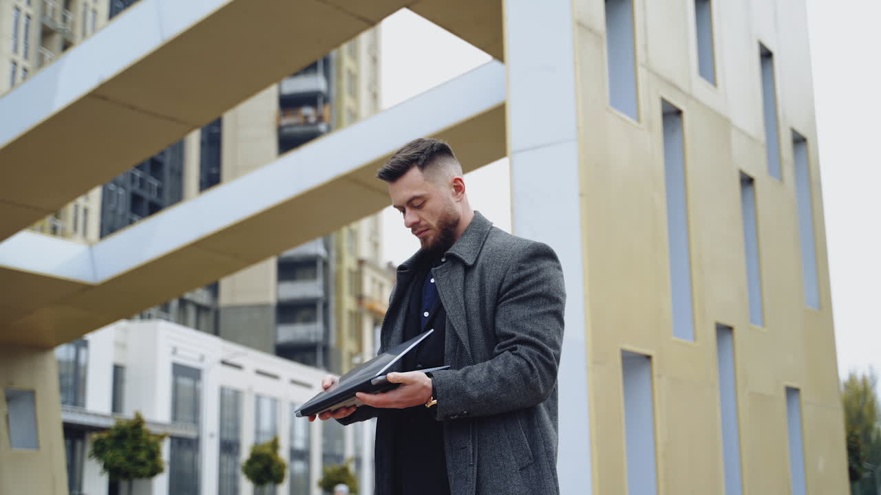 Young businessman with laptop. Businessman freelancer working on computer in city