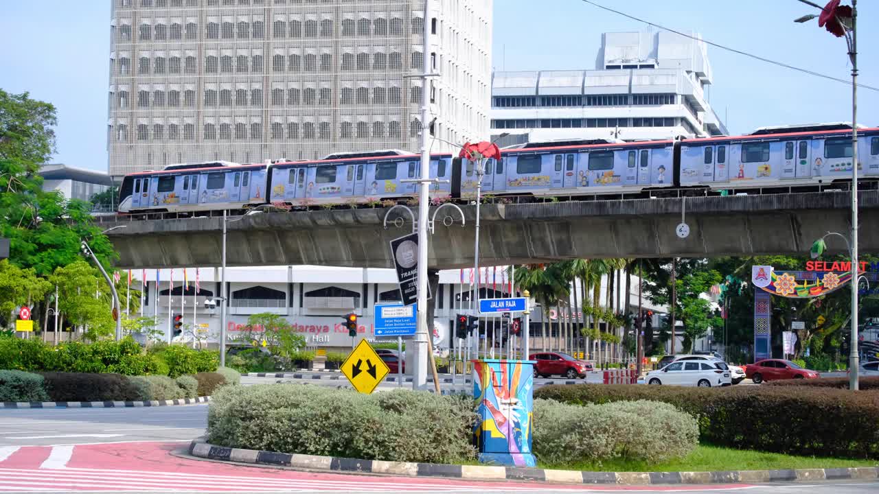Kuala Lumpur urban street view of public transport light railway train and busy car traffic on roads in capital city of Malaysia