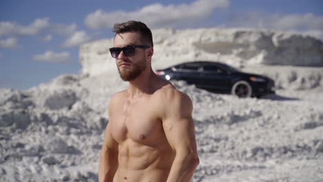 bodybuilder posing on nature. beautiful and muscular young shirtless man