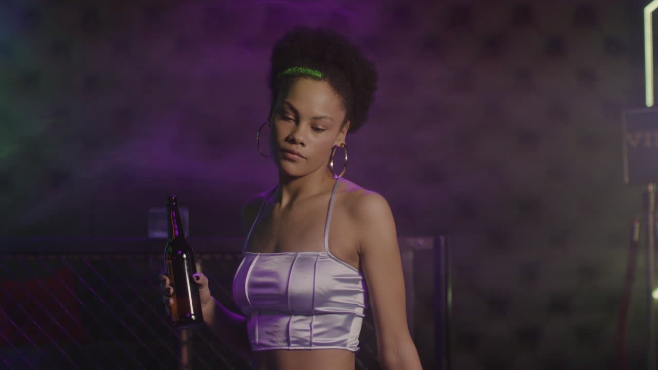 Attractive Girl Drinking Beer And Dancing At Disco