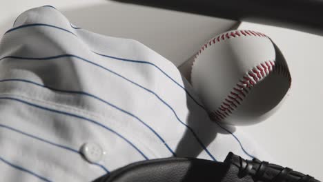 handheld close up studio baseball still life with ball catchers mitt and team jersey