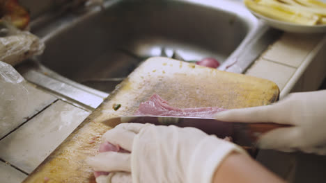 primer plano de un lomo de pescado cortado por un cuchillo para preparar ceviche