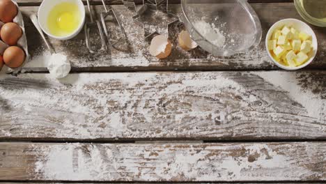 video of baking ingredients and tools lying on wooden surface with flour