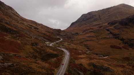 Antenne---Eine-Kurvenreiche-Straße-Zwischen-Den-Bergen,-Glencoe,-Schottisches-Hochland,-Schottland