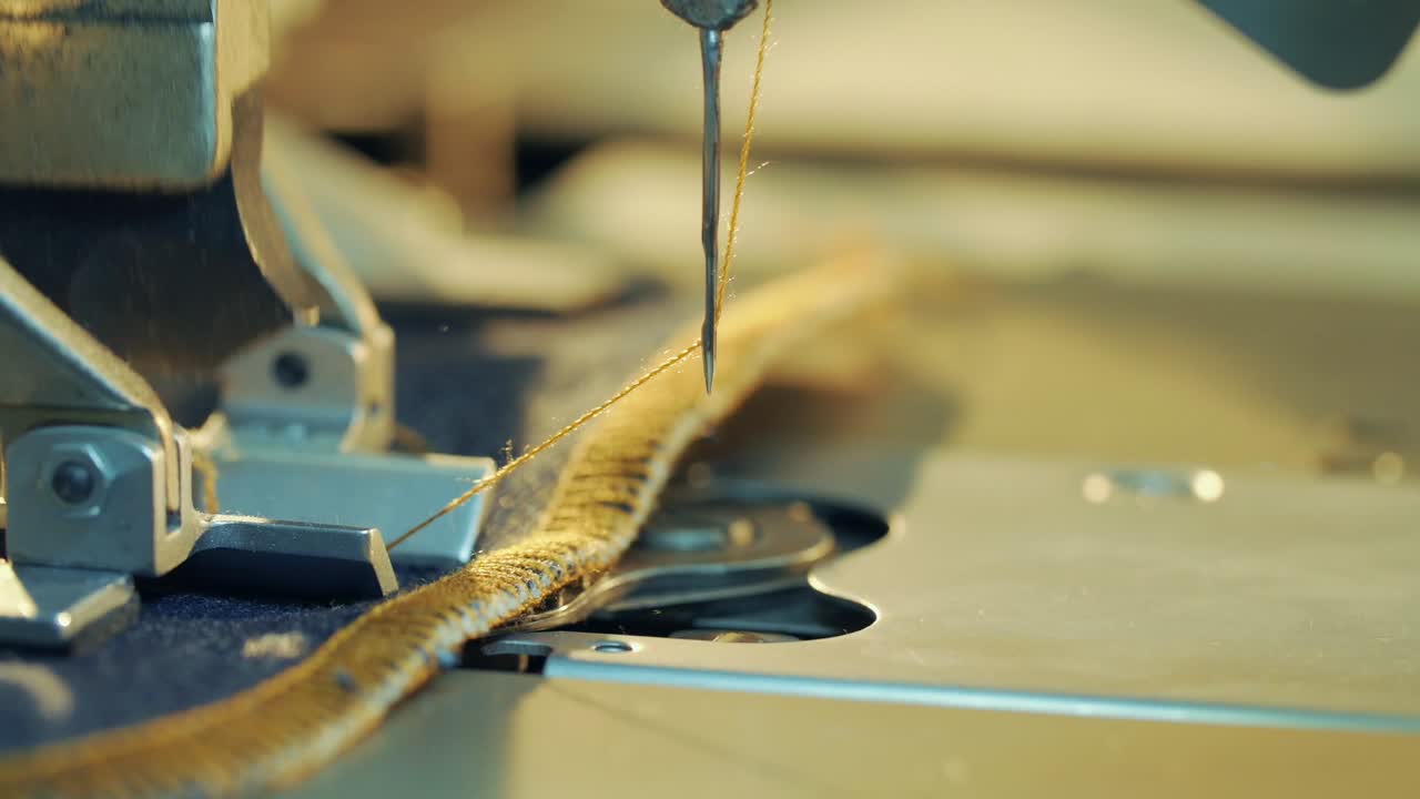 Close-up shot of sewing machine opening buttonhole for jeans