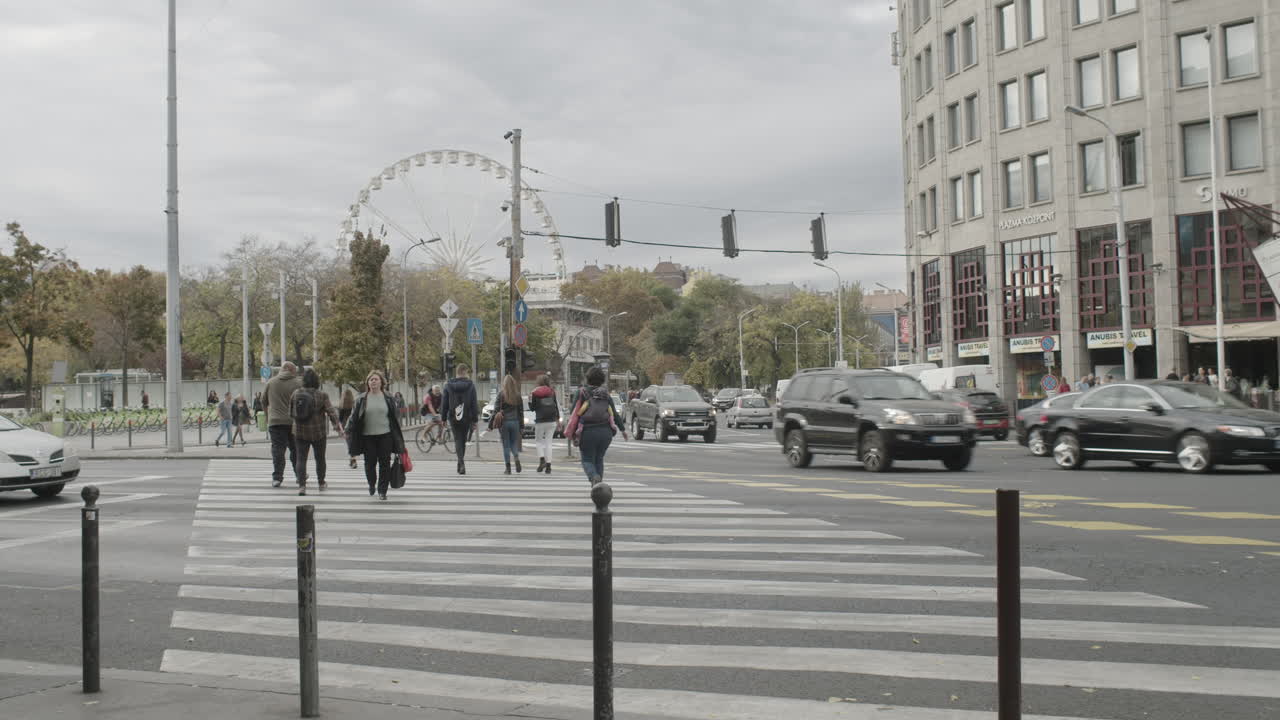 People crossing Bajcsy Zsilinszky road at a crosswalk in Budapest.