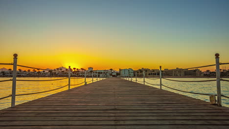 Looking-along-a-wooden-dock-or-pier-on-the-Red-Sea-in-Egypt-at-sunset---time-lapse