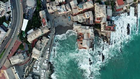 Top-down-drone-riser-over-Boccadasse-beach-on-Genoa-Ligurian-coastline,-Italy