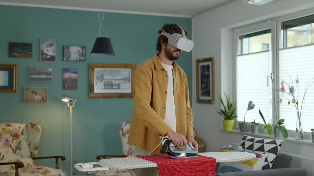 hombre adulto de mediana edad planchando ropa con tecnología de gafas de realidad virtual en un hogar moderno