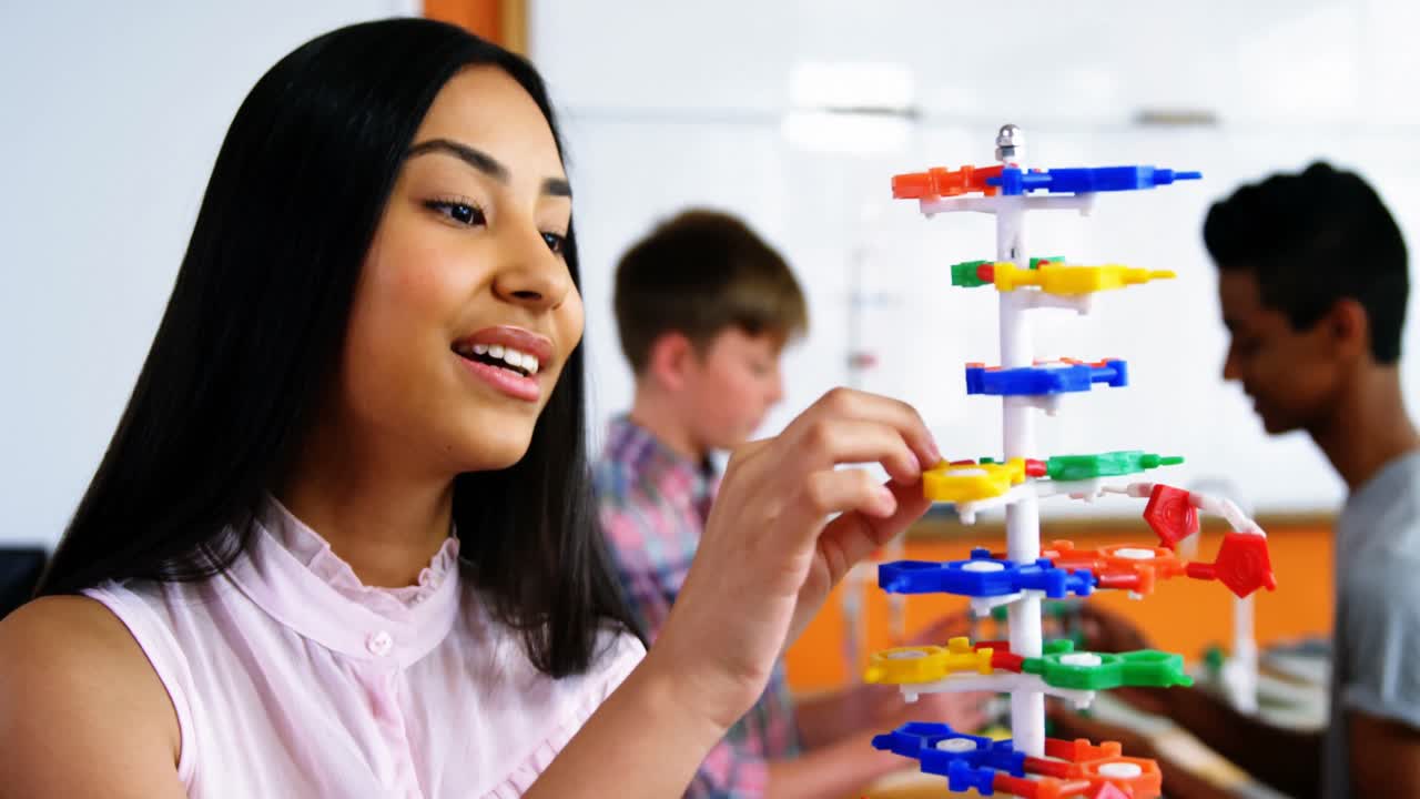 estudiante experimentando con un modelo de molécula en el laboratorio de la escuela