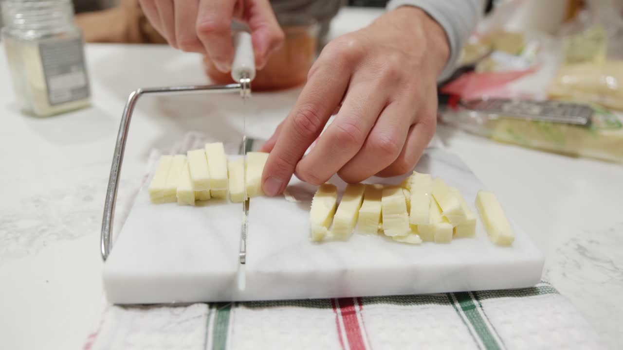 una persona cortando queso mozzarella usando un bloque cortador de queso en cámara lenta, cierre estático