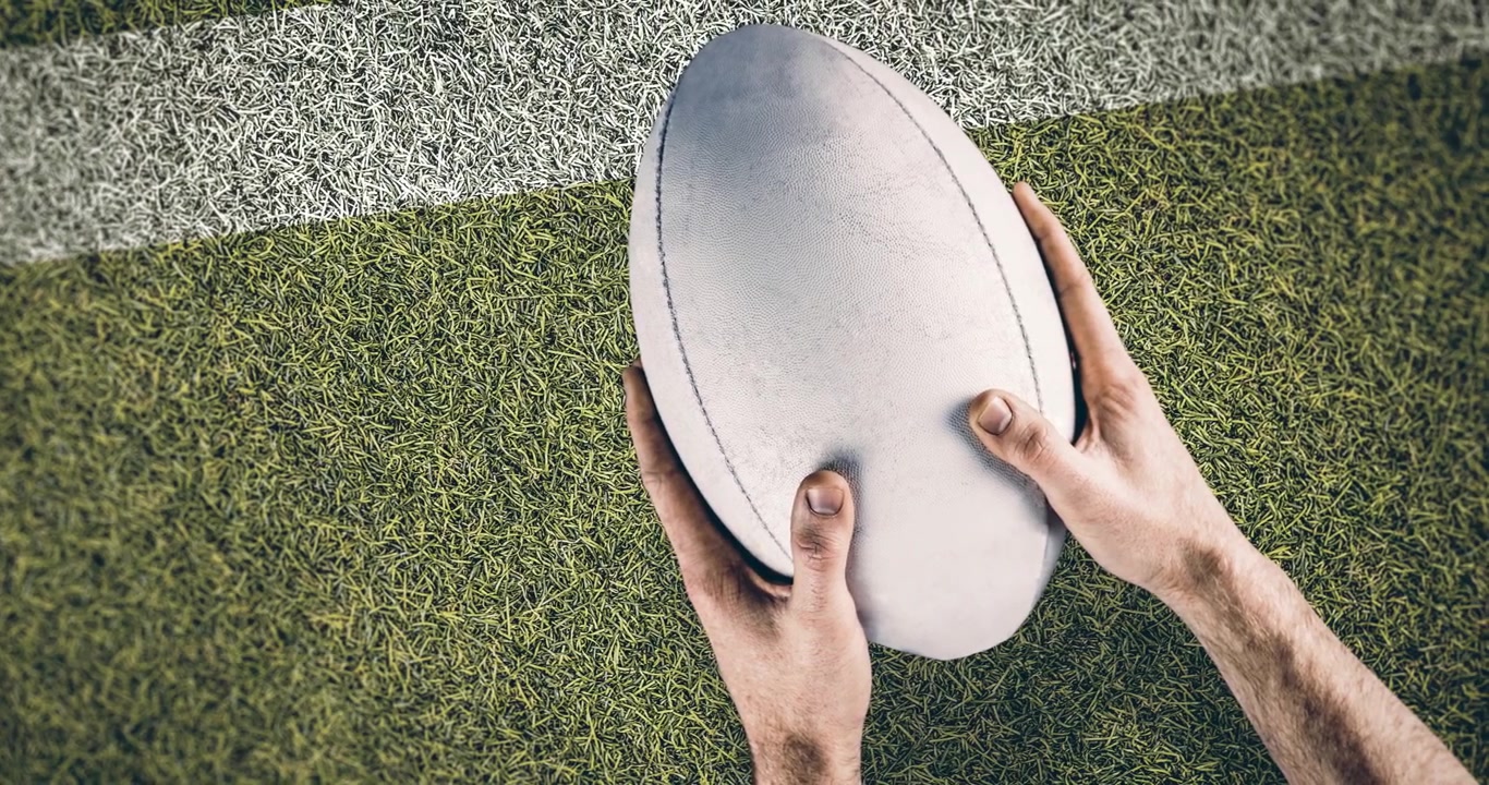 Animation of hands of caucasian male rugby player holding ball over stadium