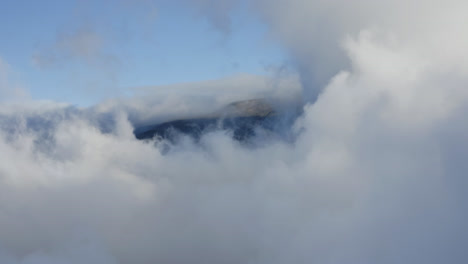 nubes blancas cubriendo y escondiendo el volcán haleakala en maui hawai en un día nublado