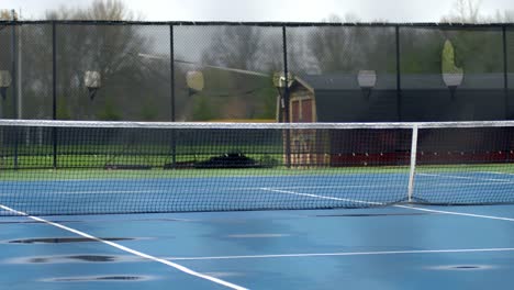 panning close-up of blue tennis net on court