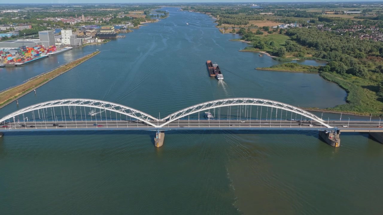 Splendida vista aerea del ponte Merwede nei Paesi Bassi, con una nave mercantile che naviga sul fiume e auto che lo attraversano.