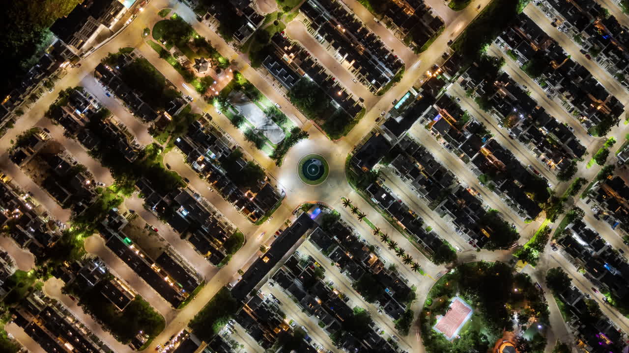 Night time hyperlapse of the traffic inside a gated community in the evening seen from above flying in circle