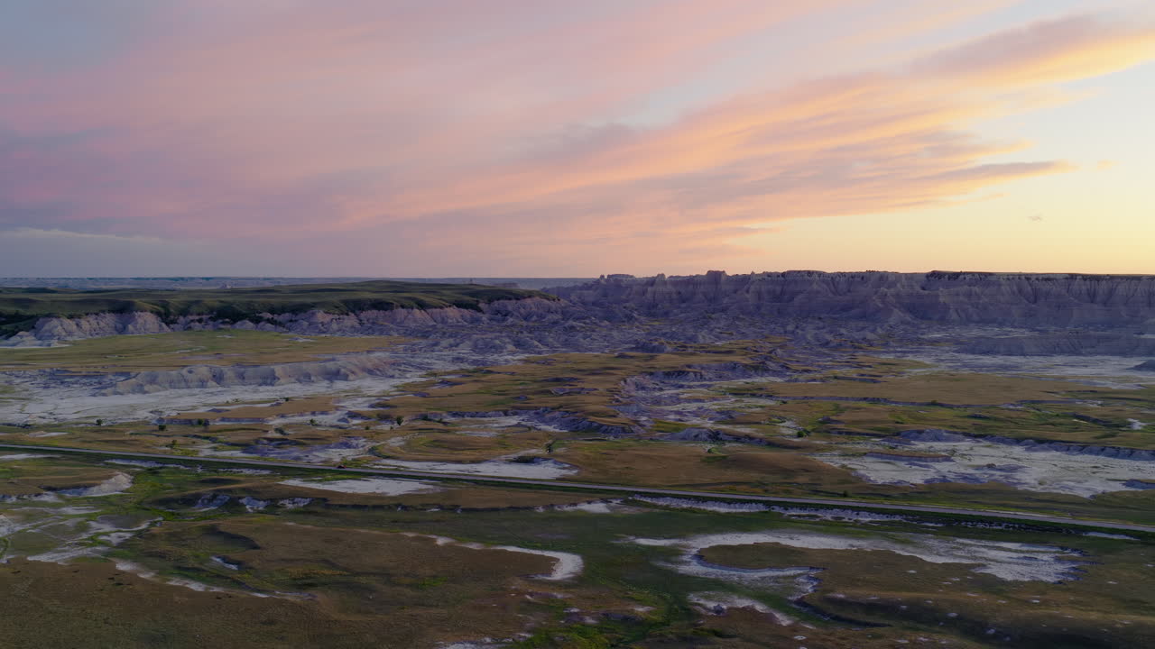 Aerial Journey Across Dramatic Badlands Formations at Sunset Hour